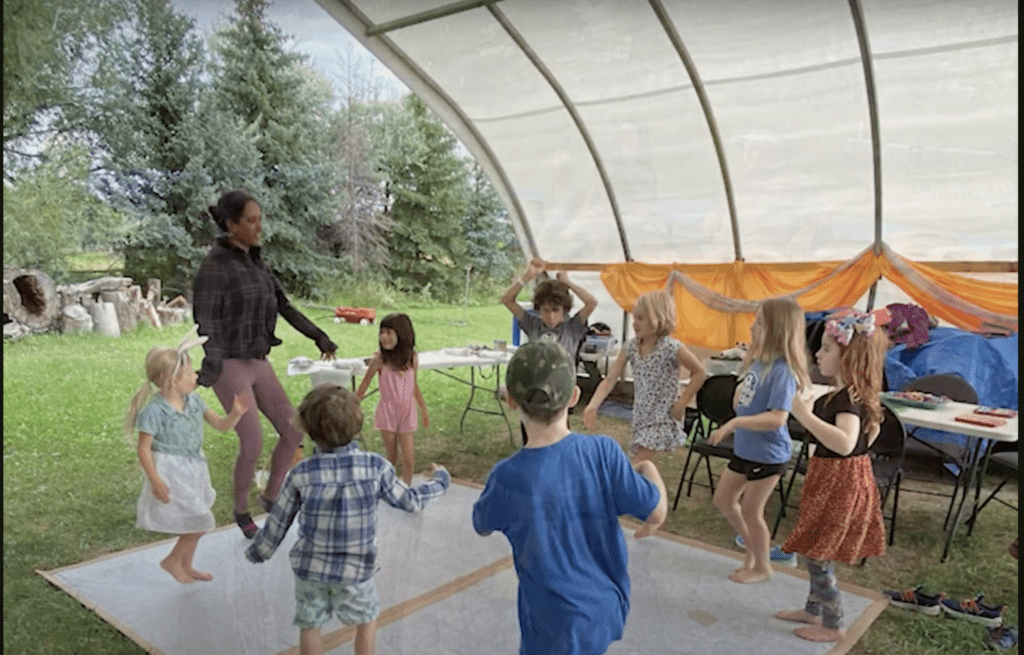 Kids doing yoga at summer camp on farmland